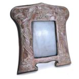 An Art Nouveau copper picture frame with repousse decoration of a maiden picking apples.