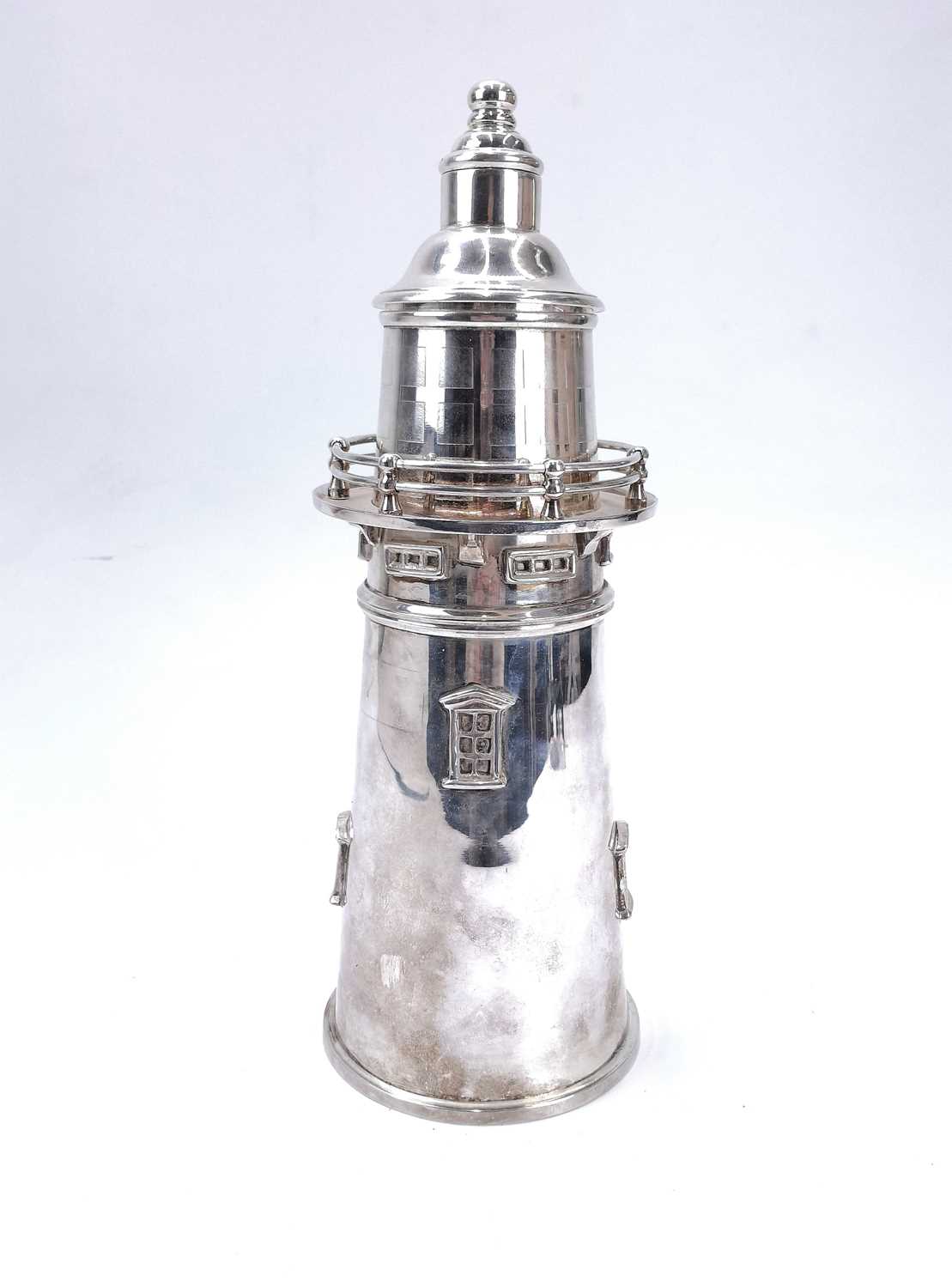 A silver plated lighthouse cocktail shaker.