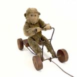 A 1930s plush monkey on a cart probably Steiff.