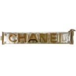 A Chanel light gold tone and gold calfskin leather logo bracelet.