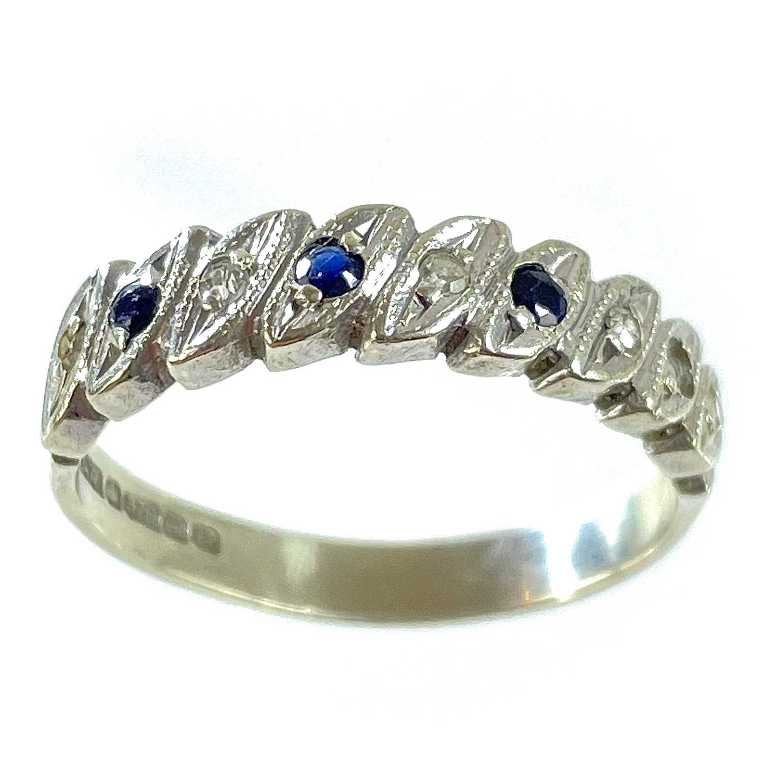 A 9ct white gold diamond and sapphire eight stone set half eternity ring.