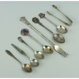 A silver pickle fork and minor silver souvenir spoons 134 grams