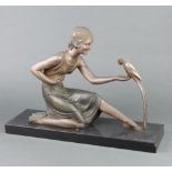 After D H Chiparus, an Art Deco spelter figure of a seated lady with parrot - "Feeding", raised on a