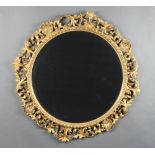 A 19th Century style circular bevelled plate wall mirror contained in a pierced and gilt wooden