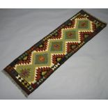 A turquoise, green and brown ground Chobi Kilim runner with all over geometric design 204cm x 61cm