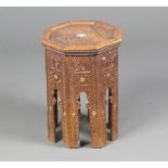 An Eastern carved octagonal hardwood table inlaid mother of pearl raised on panelled supports 40cm h
