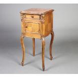 A French 19th Century carved walnut bedside cabinet of serpentine outline, the top set a pink veined