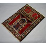 A red and blue ground Belouche prayer rug with temple design to the top 125cm x 85cm