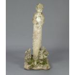 A well weathered reconstituted stone garden figure of a seated Pan on a reeded column and square