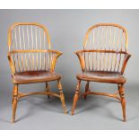 A pair of 20th Century, 18th Century style elm stick and rail back carver chairs with solid seats,