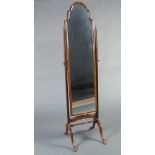 A Queen Anne style arched plate cheval mirror contained in a mahogany swing frame raised on cabriole