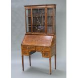 An Edwardian inlaid mahogany bureau bookcase, the breakfront upper section fitted shelves enclosed