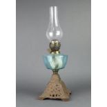 A Victorian blue opaque glass oil lamp reservoir raised on a pierced iron base with clear glass