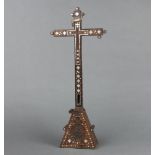A 19th Century inlaid olive wood and mother of pearl cross, raised on a triangular shaped base