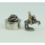 A silver trinket box with rose lid 2.5cm together with a white metal figure of a gentleman on