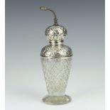 A silver mounted cut glass perfume atomiser with scroll mounts London 1912, 21cm