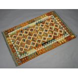 A yellow, turquoise and light brown ground Chobi Kilim with all over geometric design 153cm x 101cm