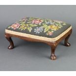 A rectangular Queen Anne style walnut footstool with floral Berlin woolwork seat raised on