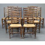 A set of 8 elm ladder back dining chairs with woven rush seats on turned supports comprising 2
