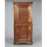 A Georgian oak double corner cabinet, the upper section with moulded cornice and cupboard enclosed