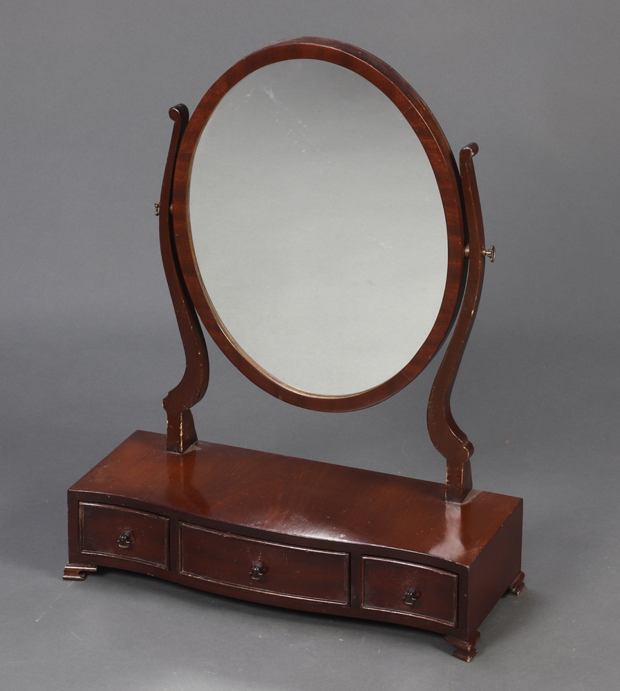 A Georgian style oval plate dressing table mirror contained in a mahogany frame, the serpentine