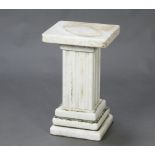 A rectangular white veined marble column, raised on a rectangular fluted marble column with square