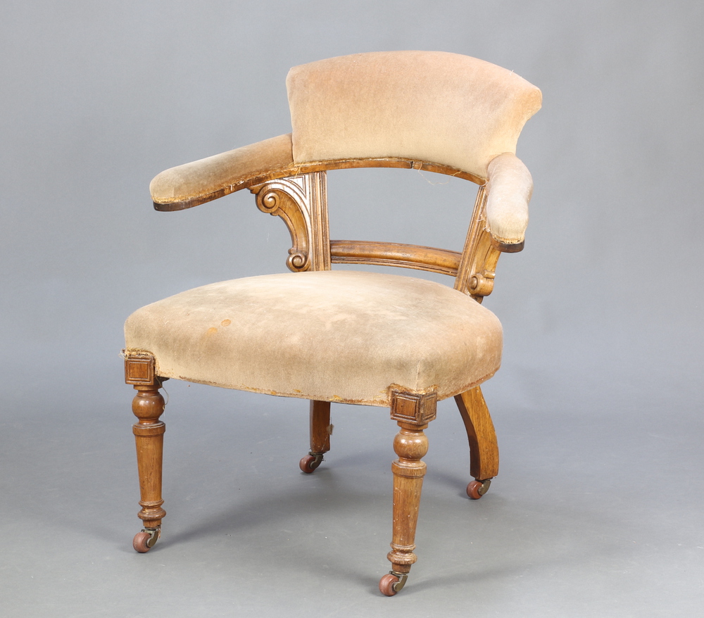 A Victorian light oak show frame tub back chair upholstered in mushroom material, raised on turned