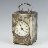 An Edwardian silver hammer pattern timepiece with scroll handle on bun feet, Birmingham 1907,