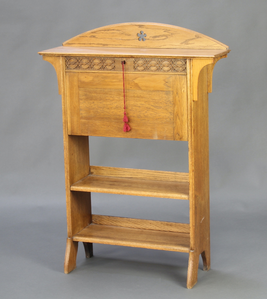 An Edwardian Art Nouveau bleached oak students bureau, the arched back with carved decoration, the