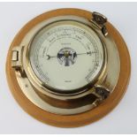 A Nauticalia ships style aneroid barometer contained in a gilt metal case 10cm x 27cm, the dial