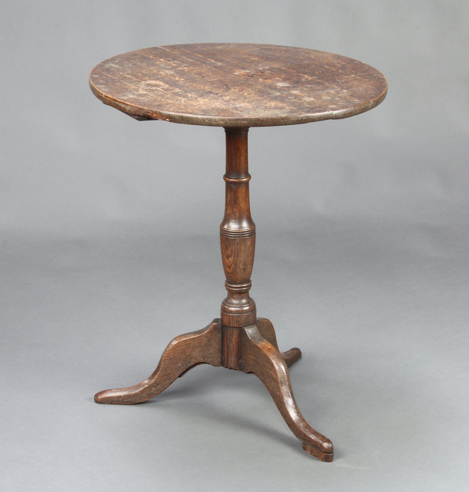 An 18th/19th Century circular oak tea table, raised on a turned column and tripod base 69cm h x 56cm