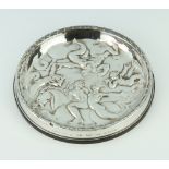 A Continental repousse silver mounted coaster decorated with classical figures 12cm
