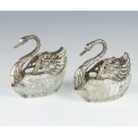 A pair of silver mounted cut glass table salts in the form of swans 11cm