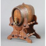 A Continental coopered oak spirit barrel, raised on a turned oak stand 21cm h x 16cm x 18cm One of