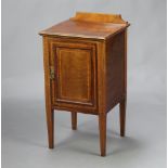 An Edwardian inlaid mahogany bedside cabinet with raised back enclosed by a panelled door, raised on