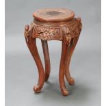 A circular Chinese carved and pierced hardwood jardiniere stand, raised on cabriole supports 61cm