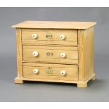 A Victorian style pine apprentice chest of 3 drawers with ceramic tore handles, raised on bun feet