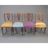 A set of 4 Edwardian inlaid rosewood dining chairs with overstuffed seats raised on square tapered