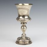 A Continental repousse white metal goblet decorated with flowers, weighted base, 20cm