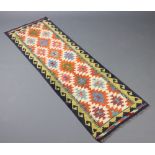 A white, orange and green ground Chobi Kilim runner with 7 stylised medallions to the centre