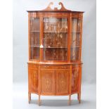 An Edwardian heavily inlaid throughout mahogany bow front display cabinet, the upper section with