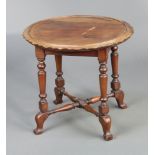 An Edwardian circular walnut occasional table, raised on turned supports with X framed stretcher