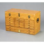 Thomas Pacconi, an oak finished collectors/jewellery cabinet with hinged lid above 12 short and 12