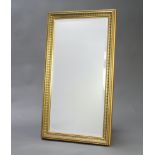 A 20th Century rectangular bevelled plate mirror contained in a decorative gilt frame 103cm x 57cm