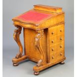 A Victorian inlaid figured walnut Davenport of serpentine outline, the top having stationery box