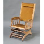 An American bleached mahogany rocking chair with bobbin turned decoration, upholstered in light