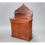 A Victorian mahogany chiffonier, the carved raised back fitted a shelf, the base fitted a secret