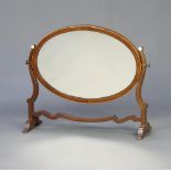 A 19th Century oval bevelled plate dressing table mirror contained in a mahogany swing frame 48cm