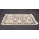 A Caucasian style brown and white ground rug with 2 octagons to the centre within a multi row border
