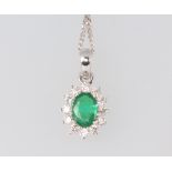 A white metal oval emerald and diamond pendant 18mm, the emerald approx. 0.7ct, the brilliant cut